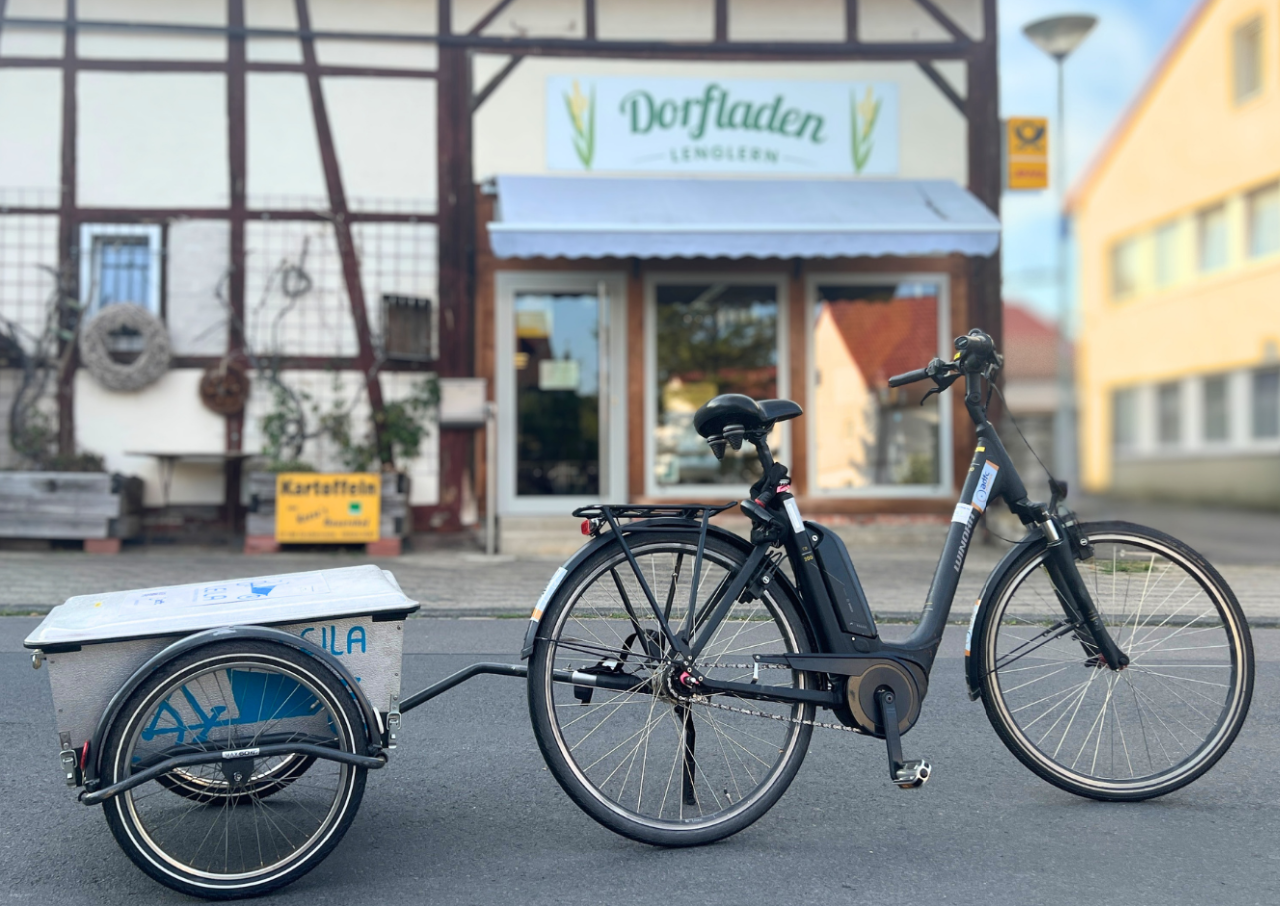 E-Bike mit Anhänger vor dem Dorfladen Lenglern